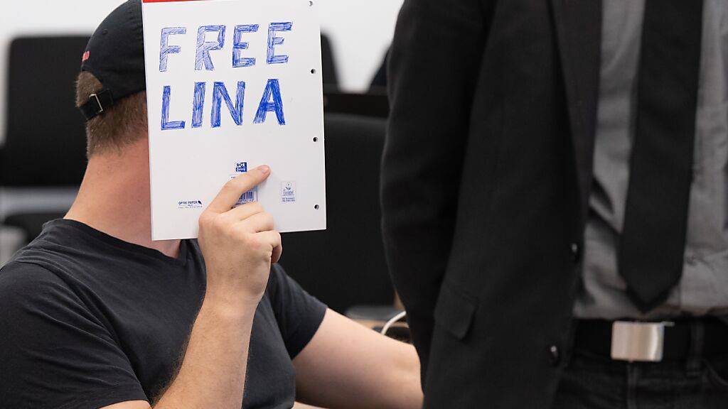 ARCHIV - Ein Angeklagter sitzt bei der Fortsetzung des Prozesses im Oberlandesgericht (OLG) Dresden im Verhandlungssaal und hält einen Schreibblock mit der Aufschrift «Free Lina» vor sein Gesicht. Foto: Sebastian Kahnert/dpa