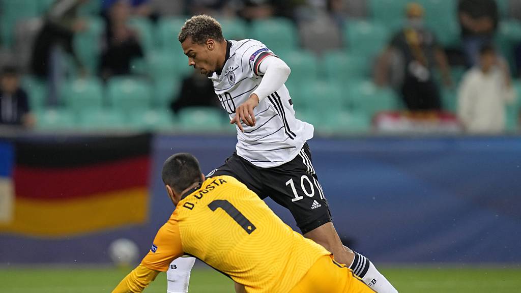 Deutschlands Lukas Nmecha umspielt den portugiesischen Torhüter Diogo Costa und erzielt das 1:0 im Final der U21-EM.