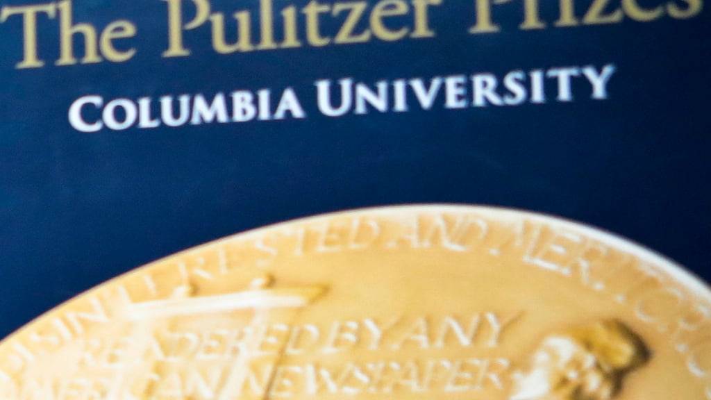 ARCHIV - Der Schriftzug «The Pulitzer Prizes» steht an der Columbia Universität auf einem Plakat über der abgebildeten Pulitzer-Medaille. Foto: Bebeto Matthews/AP/dpa