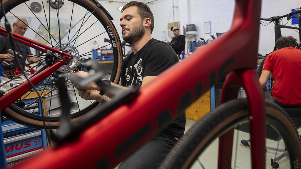 Ein Fahrradmechaniker mit einem Thömus-Velo: Der Händler übernimmt 12 Bike-World-Filialen der Migros (Symbolbild).