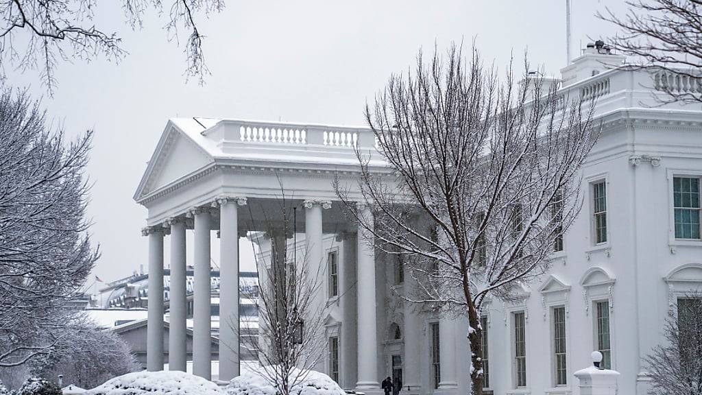 Ein Arbeiter räumt während eines Wintersturms in Washington den Schnee von der Einfahrt zum Weißen Haus. Foto: Evan Vucci/AP