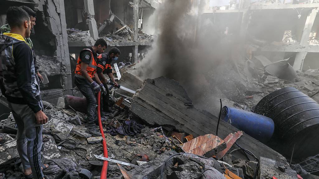 dpatopbilder - Mitglieder des palästinensischen Zivilschutzes löschen Brände, während sie nach Opfern nach einem israelischen Luftangriff suchen. Foto: Abed Rahim Khatib/dpa