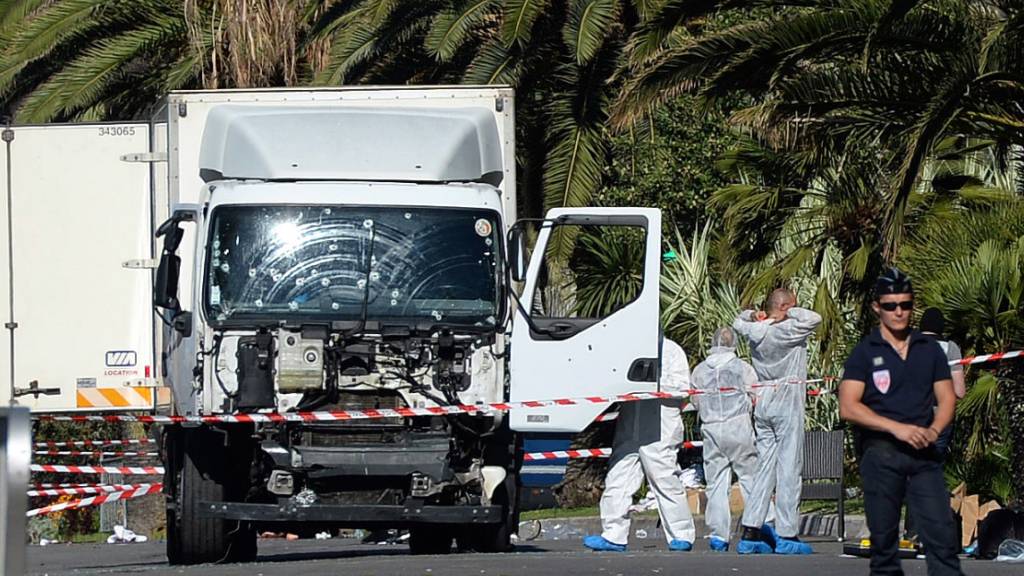 ARCHIV - Polizisten stehen um den beim Anschlag am Nationalfeiertag benutzten Lastwagen am 15.07.2016 in Nizza. Foto: picture alliance/Andreas Gebert/dpa