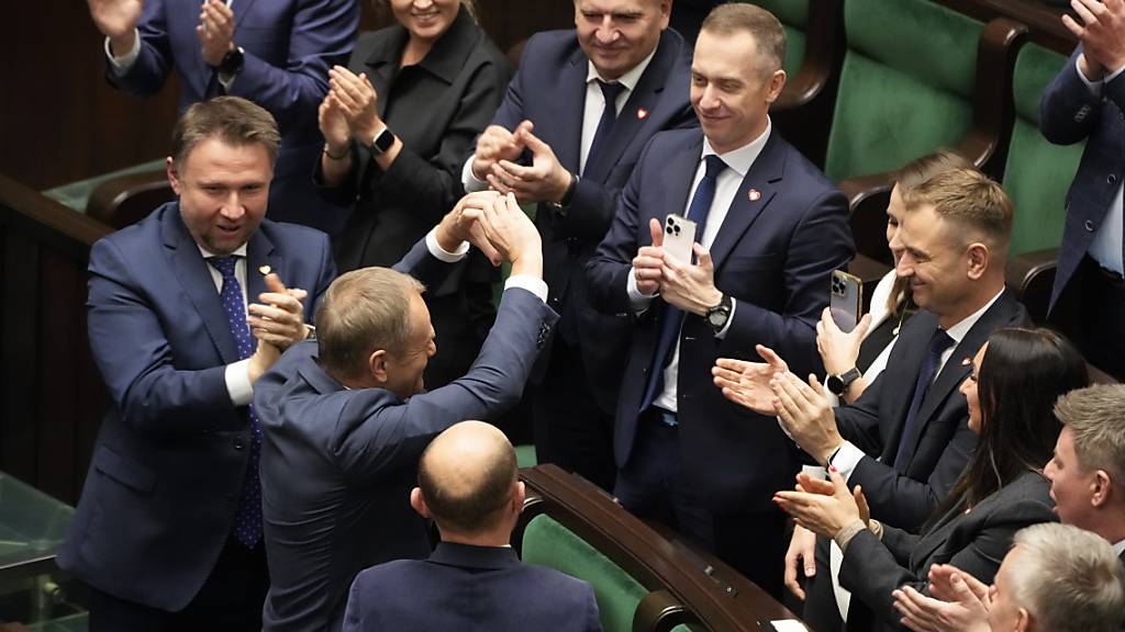 Oppositionsführer Donald Tusk (2.v.l) jubelt nach seiner Wahl zum polnischen Premierminister im Parlament. Foto: Czarek Sokolowski/AP/dpa