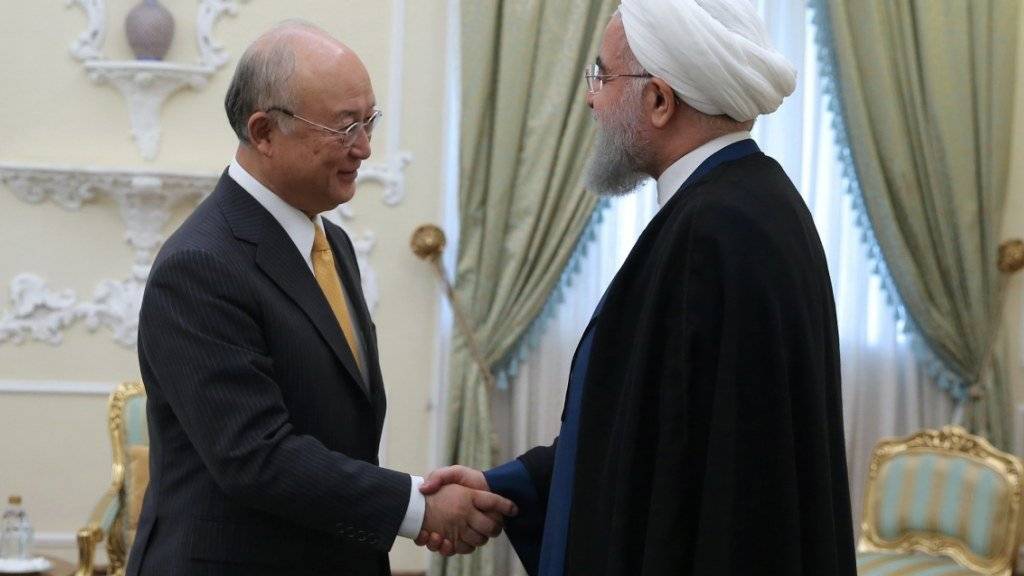 Irans Präsident Hassan Ruhani (r) begrüsst in Teheran IAEA-Chef Yukiya Amano