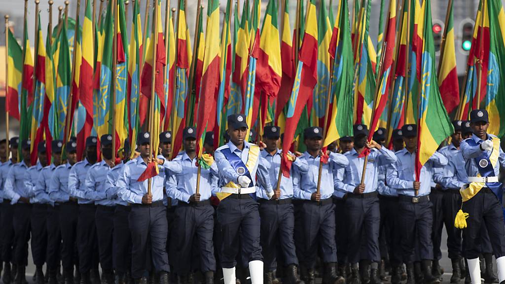 Äthiopische Polizisten, die Fahnen in den Farben der Nationalflagge halten, marschieren während einer Parade auf dem Meskel-Platz, um die neue Polizeiuniform zu präsentieren und an die Wahrung der Unparteilichkeit sowie das Respektieren des Gesetzes während der bevorstehenden Wahlen zu erinnern. Wenige Stunden vor der Wahl in Äthiopien melden die Behörden in Afrikas zweitgrößtem Land Erfolge im Kampf gegen Rebellen der Oromo-Befreiungsarmee OLA. Foto: Ben Curtis/AP/dpa