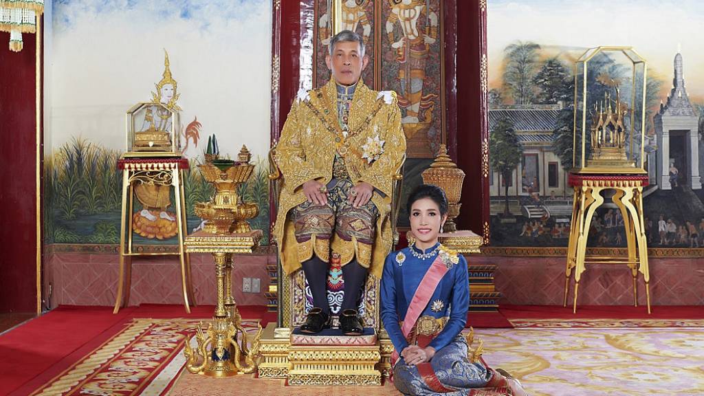 HANDOUT - ARCHIV - König Maha Vajiralongkorn von Thailand sitz auf seinem Thron, während neben ihm Sineenat Wongvajirapakdi kniet. Vajiralongkorn hat seiner im vergangenen Herbst verstoßenen offiziellen Geliebten alle königlichen und militärischen Titel wiederverliehen. Foto: Thailand Royal Office/AP/dpa - ACHTUNG: Nur zur redaktionellen Verwendung im Zusammenhang mit der aktuellen Berichterstattung und nur mit vollständiger Nennung des vorstehenden Credits