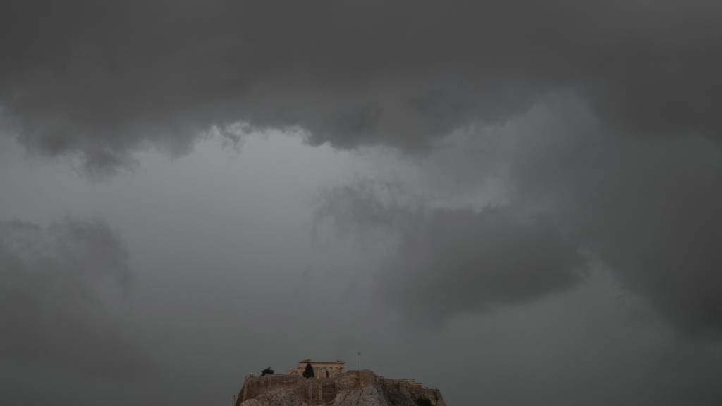ARCHIV - Graue Wolken bedecken den Himmel über dem Akropolis-Hügel während eines Regenschauers. Foto: Thanassis Stavrakis/AP/dpa