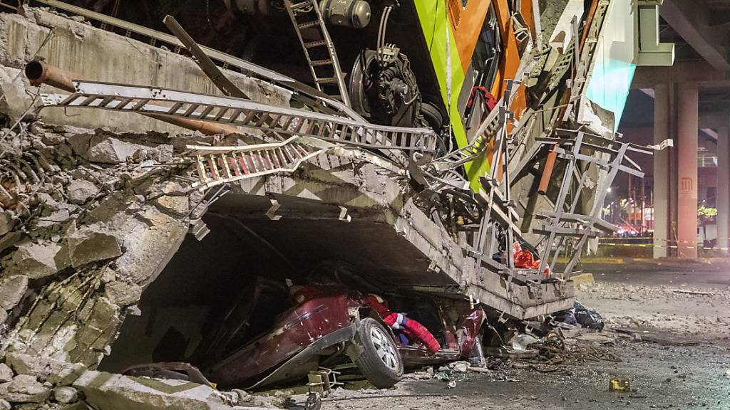 Ein Auto liegt unter Trümmern, nachdem ein Brückenabschnitt der U-Bahn-Linie 12 in Mexiko-Stadt zusammengebrochen war. Zwei Waggons stürzen auf eine viel befahrene Straße. Foto: Jair Cabrera Torres/dpa