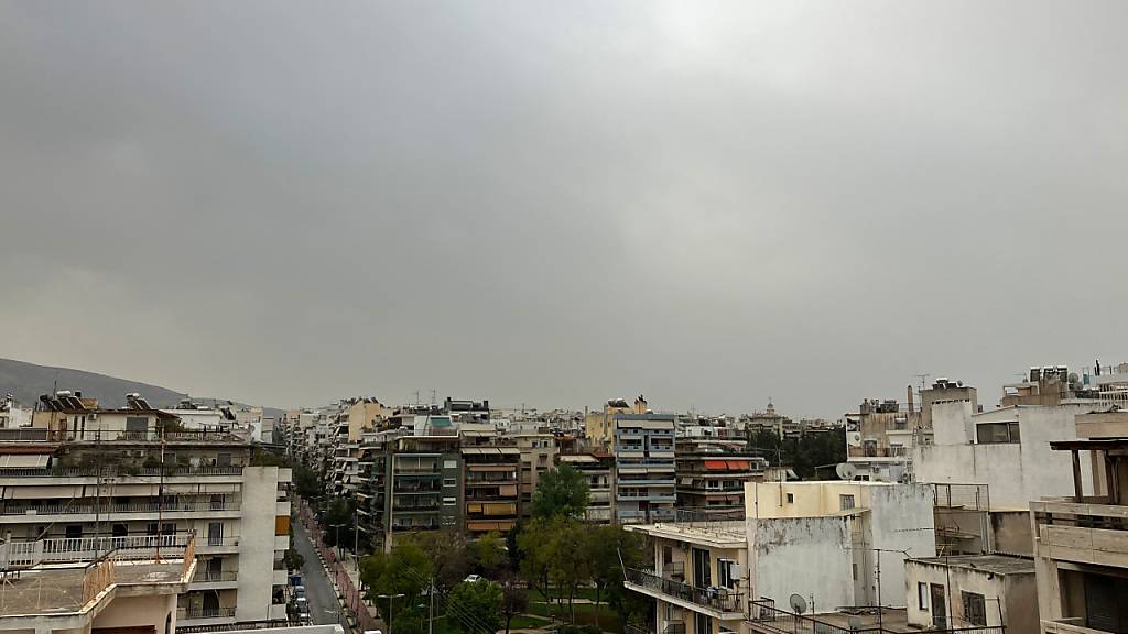 Feinster Sand aus der Sahara verdunkelt den Himmel über der Stadt. Foto: Alexia Angelopoulou/dpa