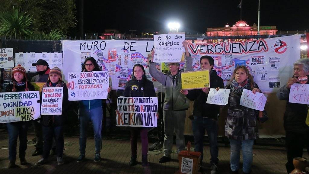 Demonstranten halten Schilder hoch gegen Präsidentschaftskandidatin Keiko Fujimori.