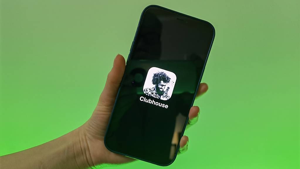 Eine Nutzerin der Social-Media-App Clubhouse zeigt ihr Smartphone mit dem Logo der Audio-Anwendung.