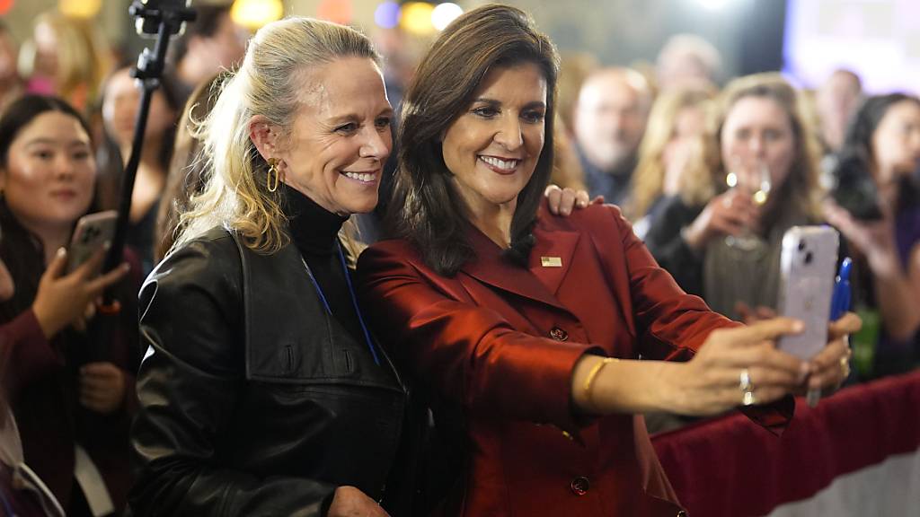 dpatopbilder - Nikki Haley (Republikaner, Mr), ehemalige UN-Botschafterin der USA und US-Präsidentschaftsbewerberin, macht ein Bild mit einer Unterstützerin nach der Vorwahl in South Carolina in Charleston. Foto: Chris Carlson/AP/dpa