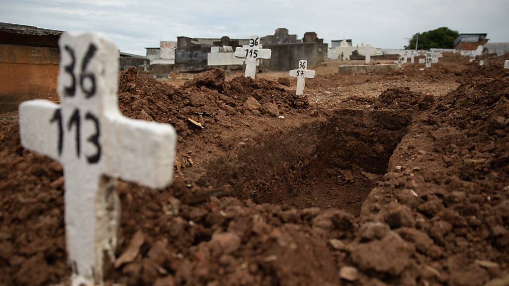 dpatopbilder - Ein einfaches Kreuz ohne Namen und mit einer Nummer steht an einem offenen Grab am Friedhof von Iraja. Foto: Fernando Souza/dpa