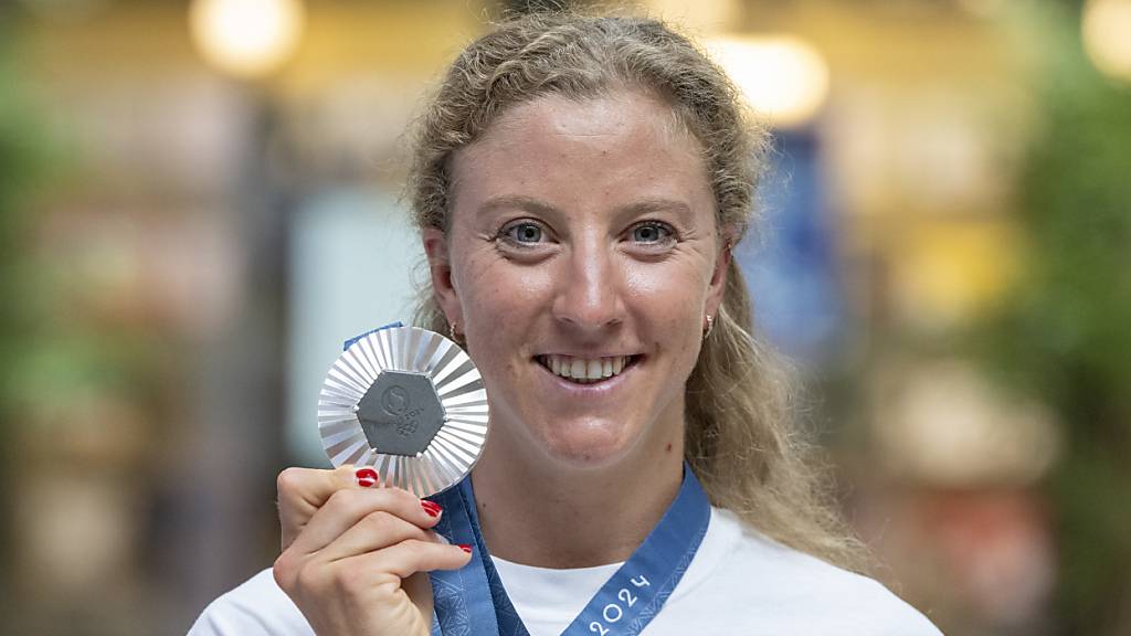 Die Zürcher Triathletin Julien Derron präsentiert bei der Ankunft am Bahnhof Basel ihre Silbermedaille