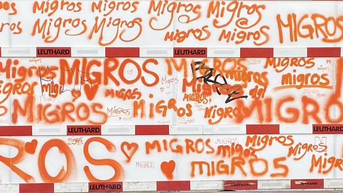Kreativ-Gang der Migros sprayt Baustellenwand in Zürich orange