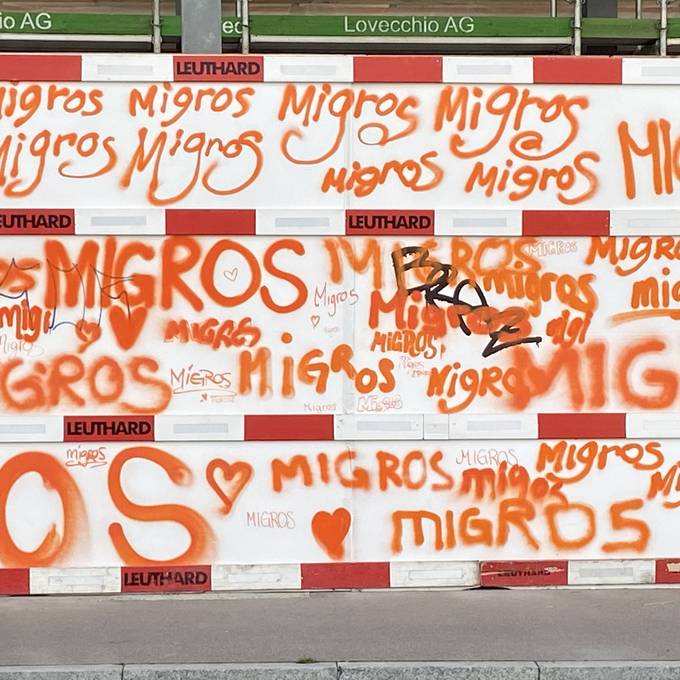 Kreativ-Gang der Migros sprayt Baustellenwand in Zürich orange