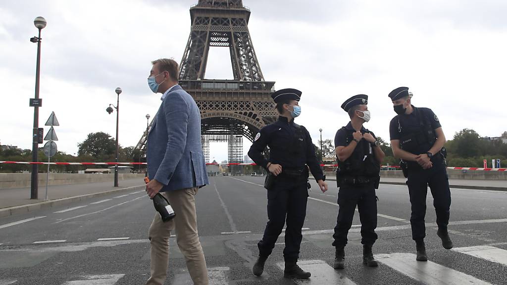 Französische Polizisten sichern das Gebiet um den Eiffelturm. Die Pariser Polizei hat nach einer Bombendrohung das Gebiet um den Eiffelturm evakuiert. Foto: Michel Euler/AP/dpa