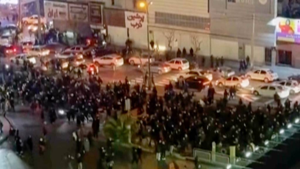 HANDOUT - Dieses Videostandbild, das von einer Person aufgenommen wurde, die nicht bei Associated Press angestellt ist, und das AP außerhalb des Irans erhalten hat, zeigt Menschen, die eine Kreuzung während eines Protests blockieren. Foto: Uncredited/UGC/AP/dpa - ACHTUNG: Nur zur redaktionellen Verwendung im Zusammenhang mit der aktuellen Berichterstattung in den nächsten 48 Stunden und nur mit vollständiger Nennung des vorstehenden Credits