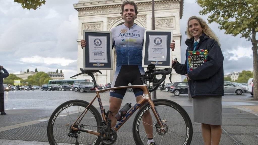 Mark Beaumont am Montag vor dem Triumphbogen in Paris, zusammen mit einer Mitarbeiterin des Guinnessbuchs der Rekorde.
