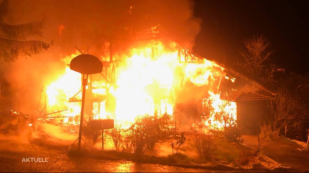 Gebäude bei Brand komplett zerstört – zwei Personen springen aus dem Fenster