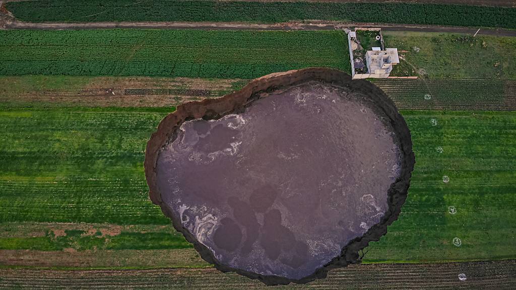 Aus der Vogelperspektive ist ein großer mit Wasser gefüllter Krater zu sehen. Foto: Karlos Pinpunk/dpa