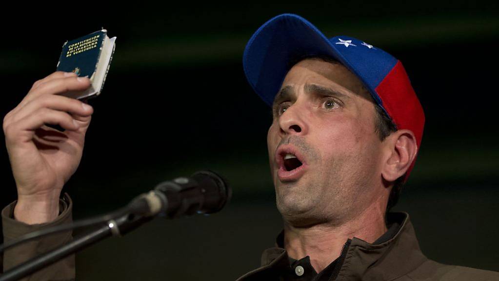 Henrique Capriles, Oppositionspolitiker in Venezuela, spricht zu seinen Anhängern und hält dabei eine Miniaturausgabe der Verfassung von Venezuela in die Höhe.