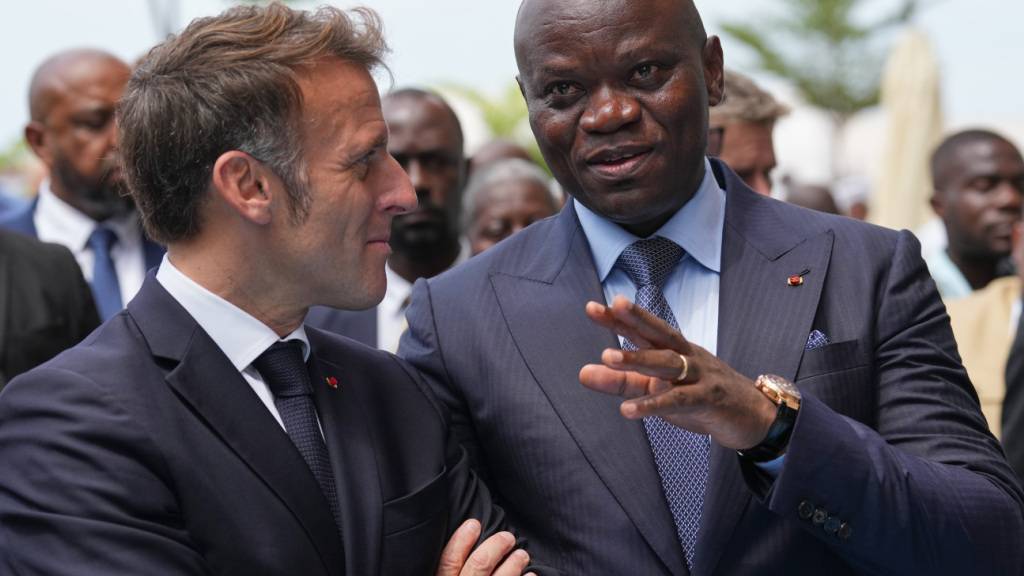 ARCHIV - Gabuns Präsident Brice Oligui Nguema (r) gestikuliert, während er mit Frankreichs Präsident Emmanuel Macron spricht, während sie das Ökogebiet Baie des Rois in Libreville besuchen. Die Regierung im zentralafrikanischen Gabun hat die Sperrung aller sozialen Medien im Land angekündigt. Foto: Thibault Camus/AP/dpa