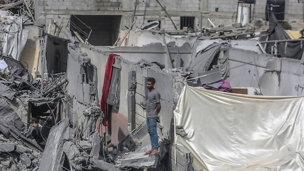 Ein Palästinenser inspiziert die Zerstörung rund um das Flüchtlingslager Bureij nach israelischen Luftangriffen. Foto: Mohammed Talatene/dpa