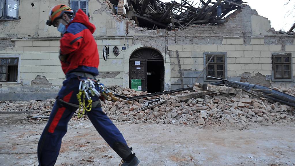 dpatopbilder - Ein Mitglied der Rettungskräfte geht vor den Trümmern eines durch ein Erdbeben eingestürzten Hauses vorbei. Foto: Uncredited/AP/dpa