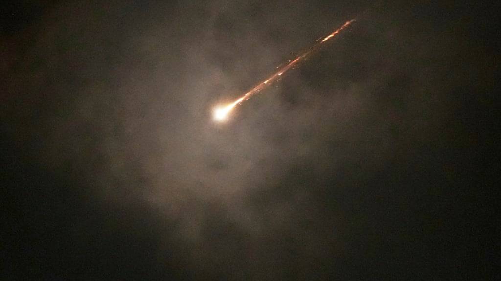 ARCHIV - Die Spur eines Geschosses ist durch die Wolken zu sehen, nachdem ein Raketenalarm nach Angriffen aus dem Iran in Jerusalem am frühen Morgen ausgelöst wurde. Foto: Ohad Zwigenberg/AP/dpa