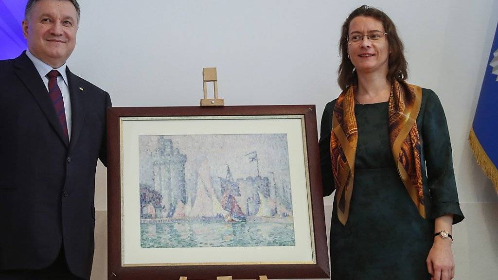 Die Ukraine hat ein gestohlenes Bild des Künstlers Paul Signac im Wert von etwa 1,5 Millionen Euro an Frankreich zurückgegeben. «Das ist Balsam auf die Wunde nach dem Feuer von Notre-Dame», sagte Frankreichs Botschafterin Isabelle Dumont (rechts) bei der Übergabe.