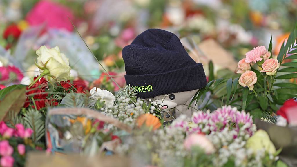 Nach dem Anschlag auf dem Magdeburger Weihnachtsmarkt liegen Kerzen, Blumen, Plüschtiere und eine Mütze der Feuerwehr vor der Johanniskirche, dem zentralen Gedenkort. Foto: Matthias Bein/dpa