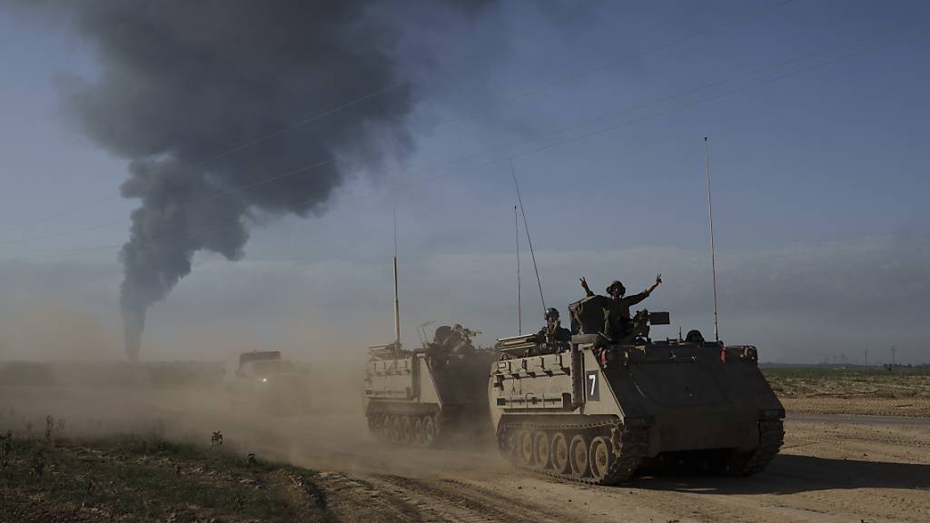 Israelische Soldaten auf gepanzerten Mannschaftstransportern (APC) der Armee nahe der Grenze zwischen Israel und Gaza, während im Gazastreifen Rauch in den Himmel steigt, vom Süden Israels aus gesehen. 