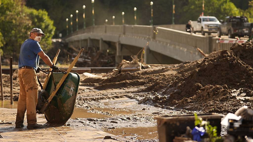 Brian McCormack macht eine Pause, nachdem er mit einer Schubkarre die Trümmer nach dem Hurrikan Helene aufgeräumt hat in Marshall, N.C. Foto: Jeff Roberson/AP/dpa