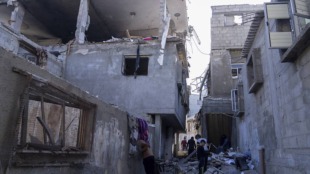 Palästinenser inspizieren ein beschädigtes Gebäude nach israelischen Luftangriffen. Foto: Fatima Shbair/AP/dpa