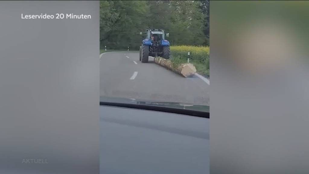 Waghalsig: Ein Traktorlenker zieht einen Baumstamm über die Strasse