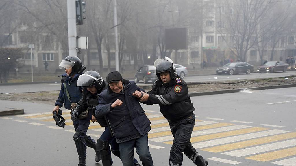 Polizeibeamte halten einen Mann während einer Demonstration in Almaty fest. Foto: Vladimir Tretyakov/AP/dpa