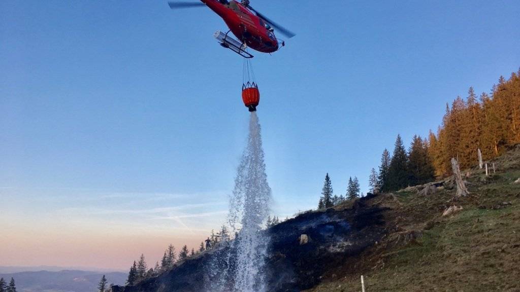 Löschen mit Wasser aus dem Gantrischsee: Ein Helikopter bekämpft den Waldbrand in Blumenstein.