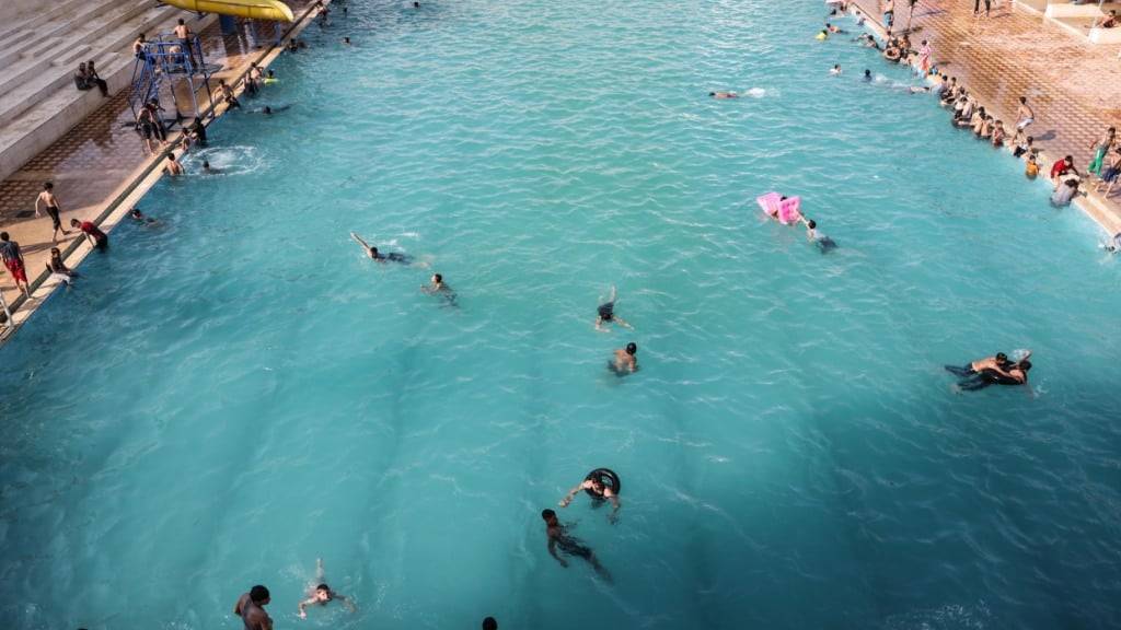 ARCHIV - Junge Syrer schwimmen in einem Pool, um sich an einem heißen Sommertag abzukühlen. Foto: Anas Alkharboutli/dpa