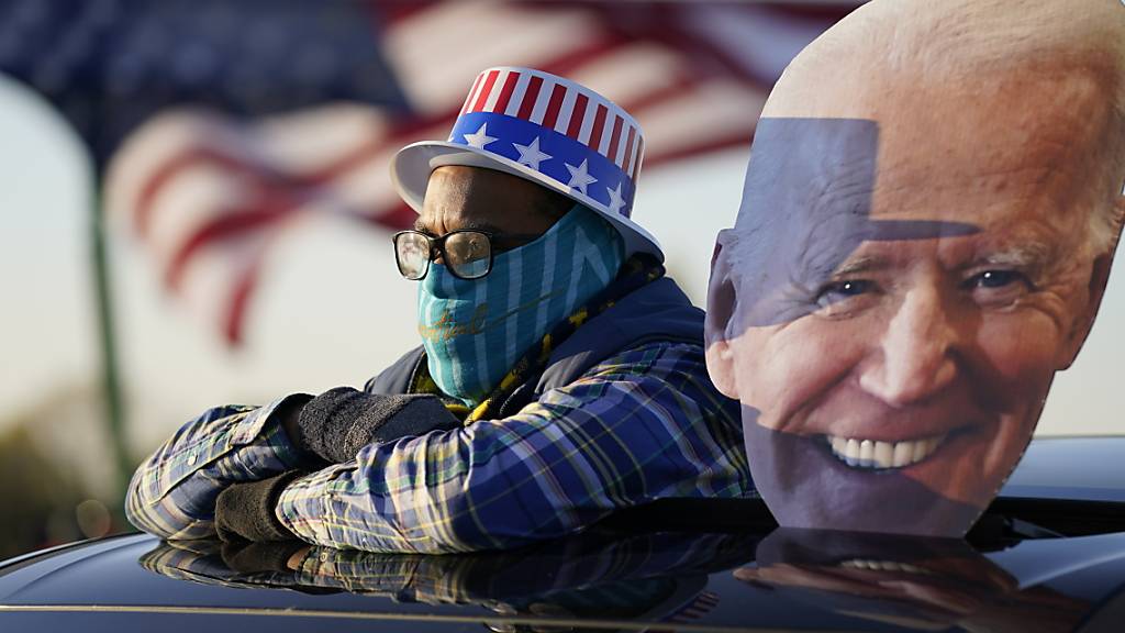 dpatopbilder - Ein Anhänger des Präsidentschaftskandidaten der Demokraten Biden schaut sich eine Wahlkampfveranstaltung von Joe Biden und und dem ehemaligen Präsidenten Barack Obama an. Foto: Andrew Harnik/AP/dpa