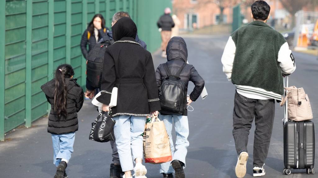 ARCHIV - Flüchtlinge gehen zu einer Unterkunft. Foto: Boris Roessler/dpa