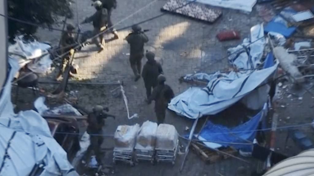 dpatopbilder - HANDOUT - In diesem Bild aus einem von den israelischen Verteidigungskräften am 15. November 2023 veröffentlichten Video gehen israelische Soldaten in der Nähe des Schifa-Krankenhauses in Gaza-Stadt. Das israelische Militär veröffentlichte. Foto: Israel Defense Forces/IDF/AP/dpa - ACHTUNG: Nur zur redaktionellen Verwendung und nur mit vollständiger Nennung des vorstehenden Credits