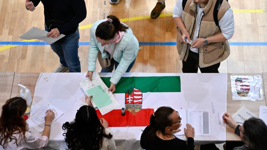 dpatopbilder - Eine Frau nimmt in einem Wahllokal während der ungarischen Parlamentswahlen die Stimmzettel entgegen. Foto: Denes Erdos/AP/dpa