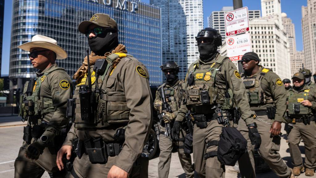 ARCHIV - Bundesbeamte der US-Einwanderungs- und Zollbehörden und der US-Zollbehörde US Customs and Border Protection gehen den West Wacker Drive entlang an einem Trump-Gebäude vorbei. Foto: Ashlee Rezin/Chicago Sun-Times/dpa - ACHTUNG: Nur zur redaktionellen Verwendung und nur mit vollständiger Nennung des vorstehenden Credits