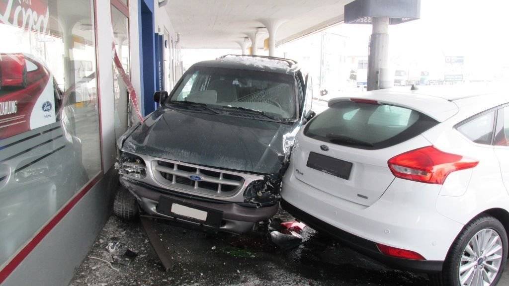 Nach der frontalen Kollision beschädigte ein Auto zusätzlich die Scheibe einer Garage und ein Ausstellungsauto.