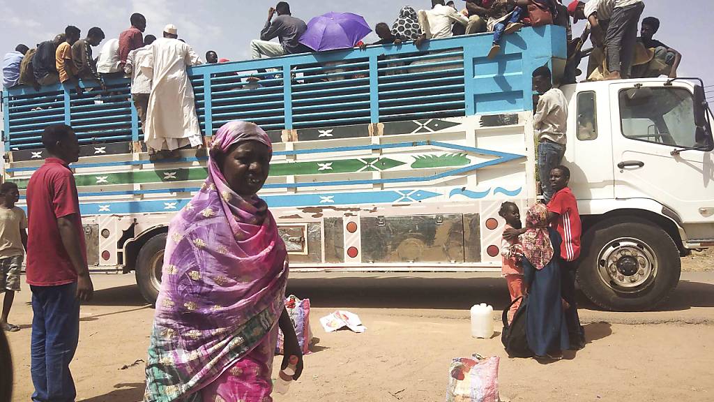 ARCHIV - Menschen besteigen in Khartum einen Lastwagen um die Stadt zu verlassen. Seit nun mehr vier Monaten bekämpfen sich die Konfliktparteien im Sudan. Foto: Uncredited/AP