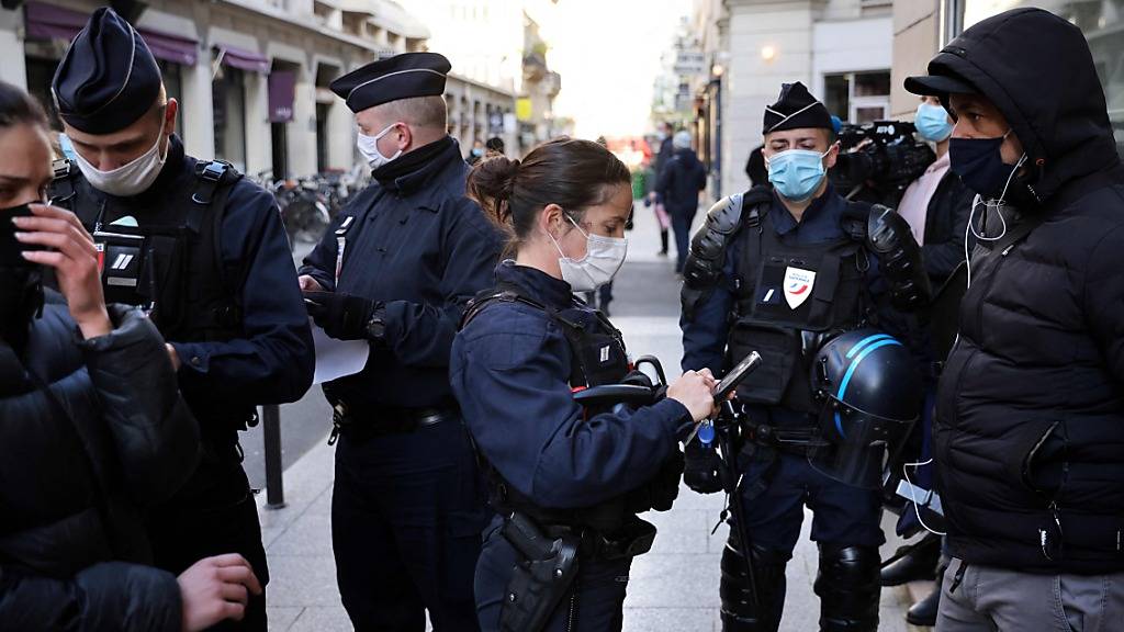 Polizisten kontrollieren Ausweise von Passanten in Paris. Foto: Thomas Coex/AFP/dpa