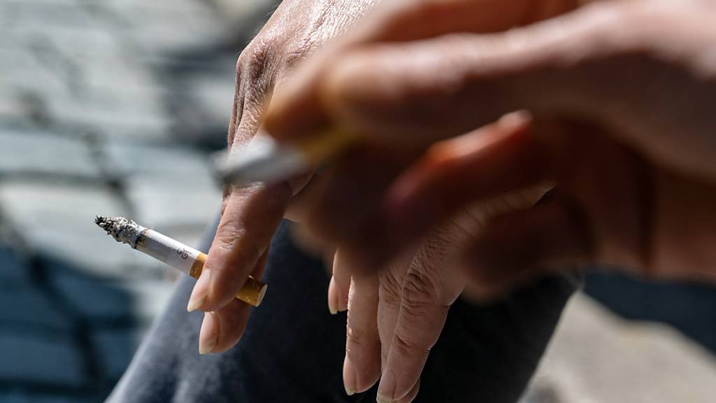 ARCHIV - Raucher halten eine brennende Zigarette in der Hand. Laut WHO erhöht Rauchen das Risiko, schwer an Covid-19 zu erkranken. Foto: Armin Weigel/dpa