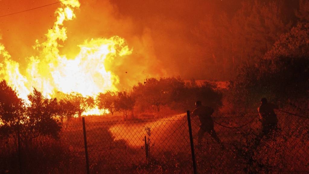 dpatopbilder - Feuerwehrleute versuchen, die Flammen in einem Wald im Dorf Avantas nahe der Stadt Alexandroupolis zu löschen. Foto: Achilleas Chiras/AP